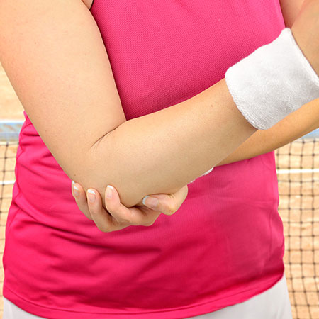Woman suffering from tennis elbow in need of chiropractor in Palo Alto