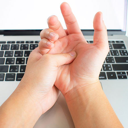 Woman suffering from carpal tunnel syndrome in need of chiropractor in Palo Alto